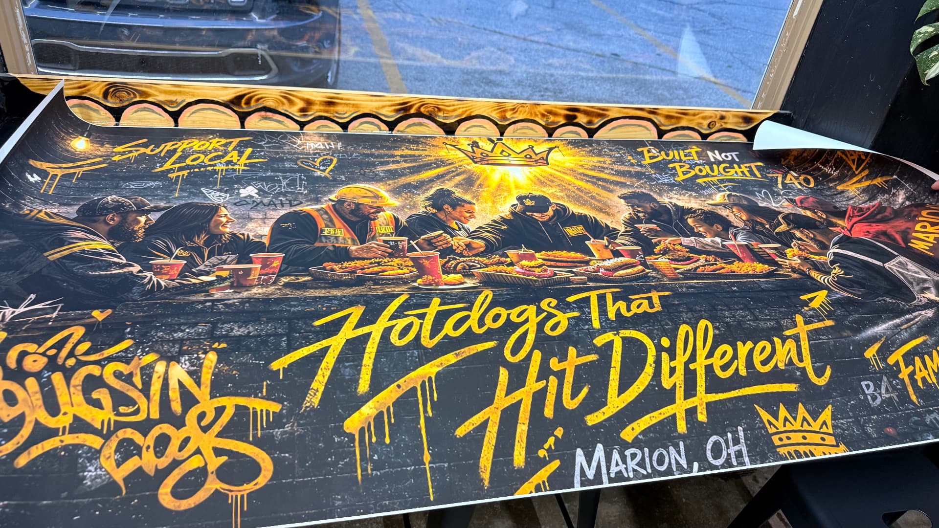 Bussin Dogs Hotdogs That Hit Different mural of a crowded table in Marion, Ohio